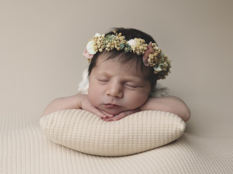 Niña bebé recién nacida apoyada sobre un cojín